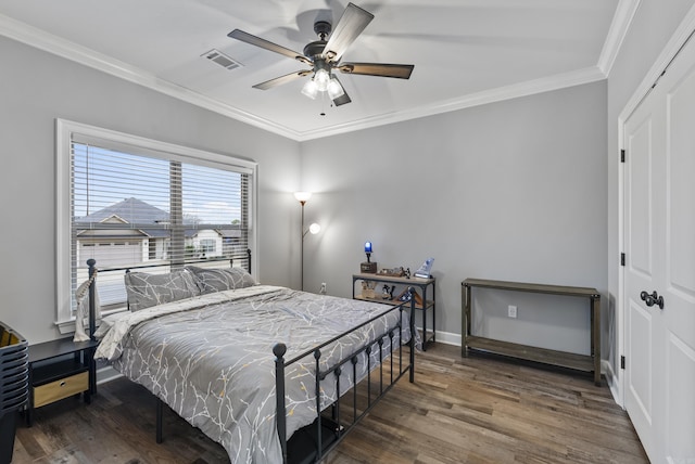 bedroom featuring crown molding, ceiling fan, dark hardwood / wood-style flooring, and a closet