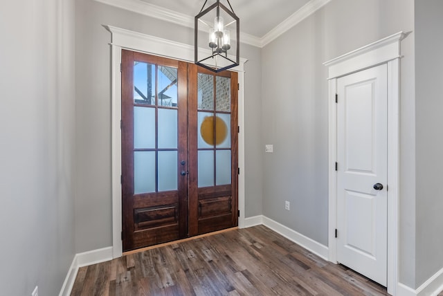 entrance foyer with dark hardwood / wood-style flooring, a notable chandelier, crown molding, and french doors