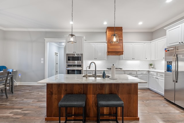 kitchen with a kitchen island with sink, white cabinets, and appliances with stainless steel finishes