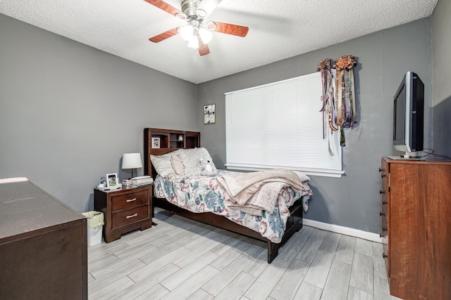 bedroom with ceiling fan, a textured ceiling, and light wood-type flooring