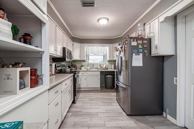 kitchen featuring tasteful backsplash, white cabinetry, sink, ornamental molding, and stainless steel appliances