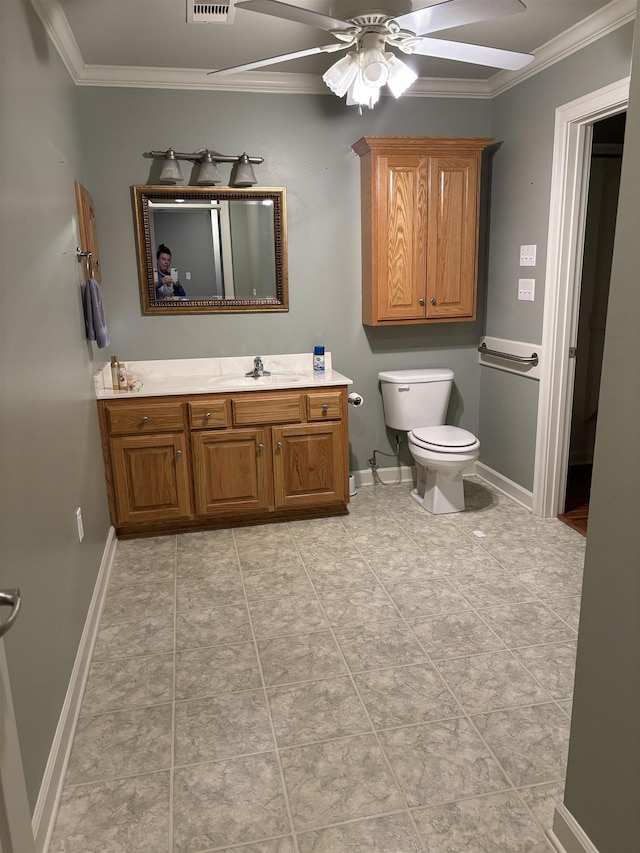 bathroom with tile patterned flooring, ornamental molding, vanity, ceiling fan, and toilet