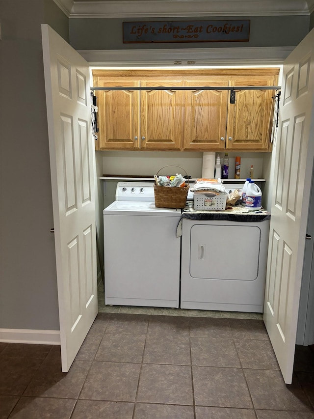 laundry room featuring cabinets, dark tile patterned floors, and washing machine and clothes dryer