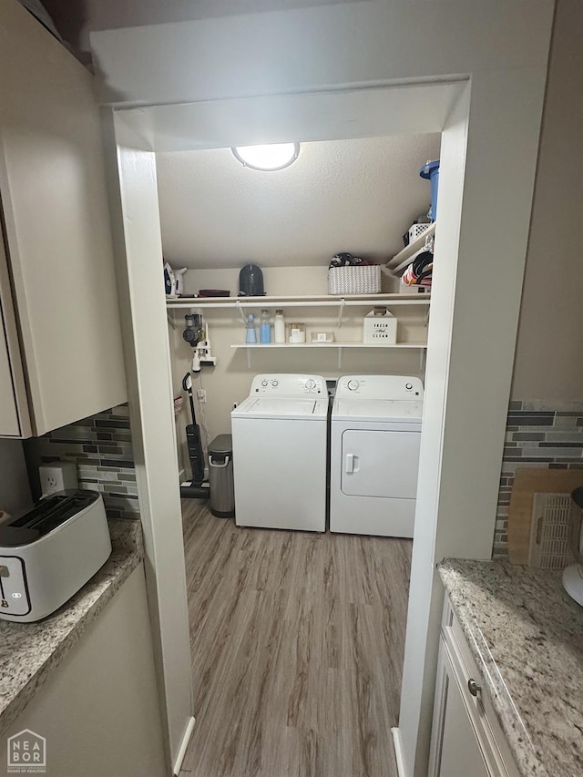 laundry area featuring light hardwood / wood-style floors and washing machine and clothes dryer