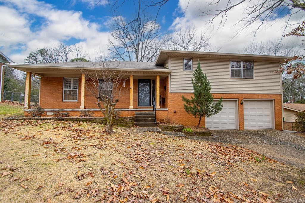 tri-level home featuring a garage and covered porch