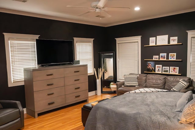 bedroom with crown molding, light hardwood / wood-style flooring, and ceiling fan