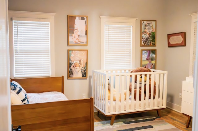 bedroom featuring multiple windows and hardwood / wood-style flooring