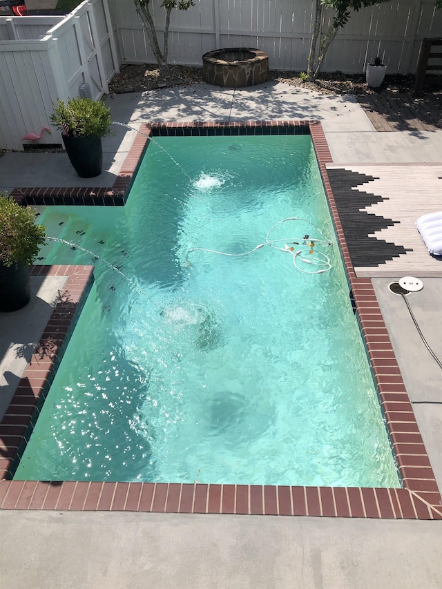 view of swimming pool featuring an outdoor fire pit