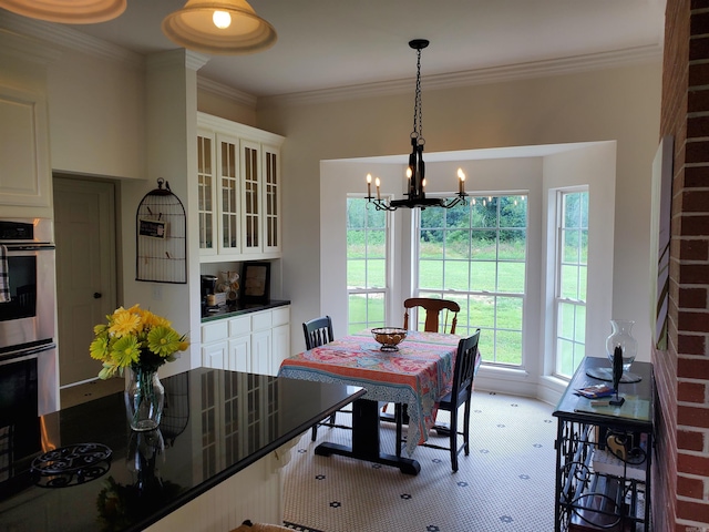 dining space with crown molding and a notable chandelier