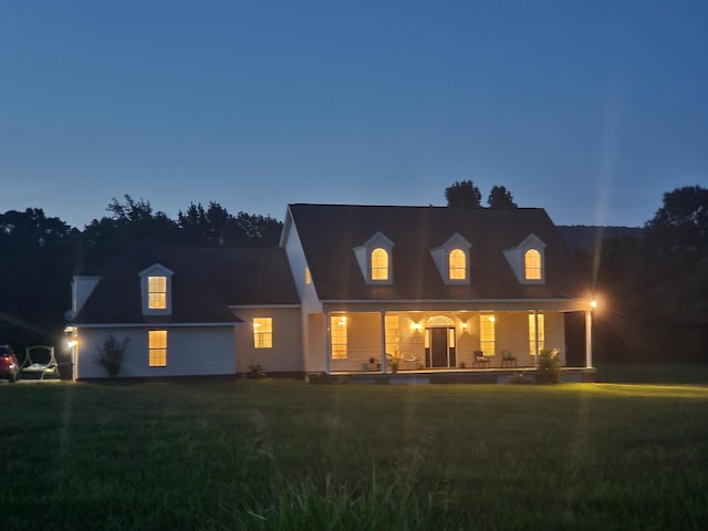 cape cod-style house with a lawn and a porch