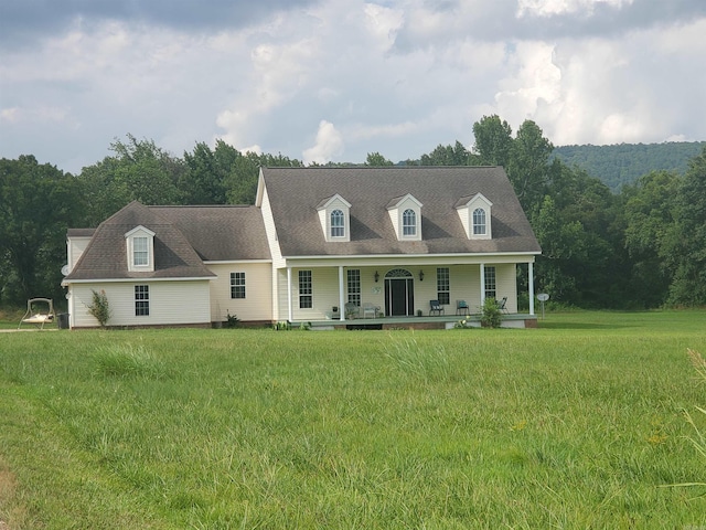 cape cod house with a porch and a front yard