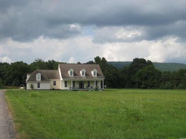 new england style home featuring a front lawn and covered porch