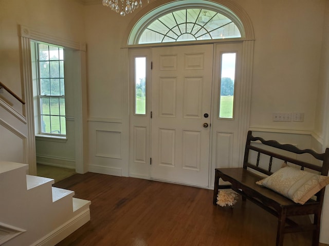 entryway with an inviting chandelier and dark hardwood / wood-style floors