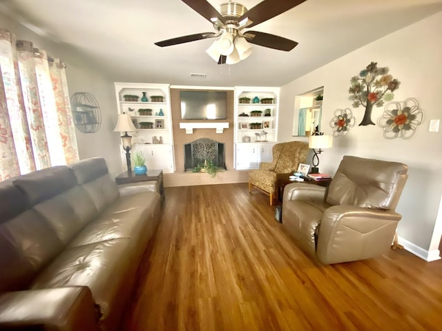 living room featuring ceiling fan, hardwood / wood-style floors, and built in features