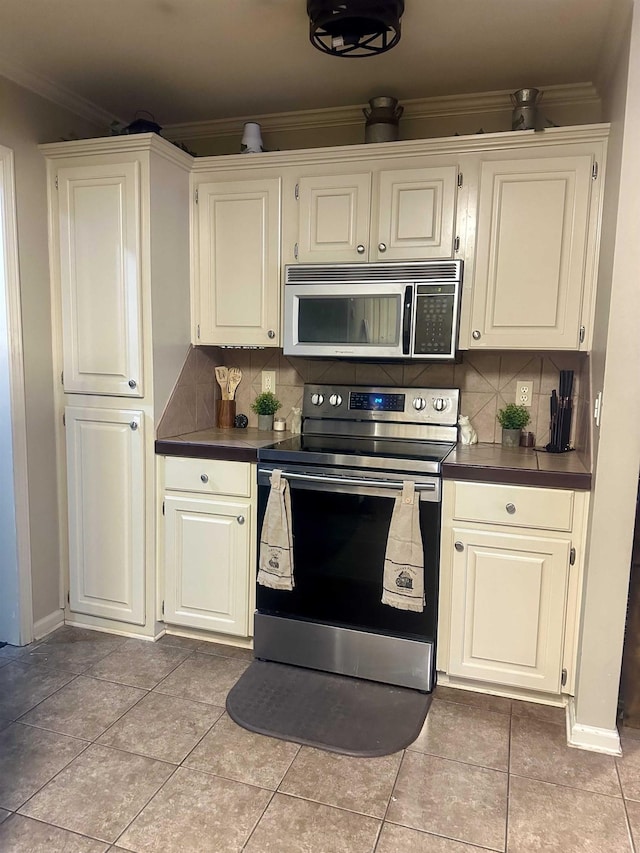 kitchen with crown molding, white cabinetry, stainless steel appliances, and tasteful backsplash