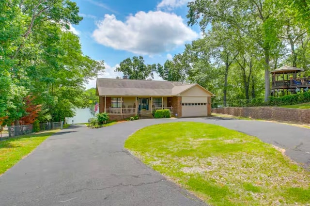 view of front of house with a front lawn, a garage, a gazebo, and covered porch