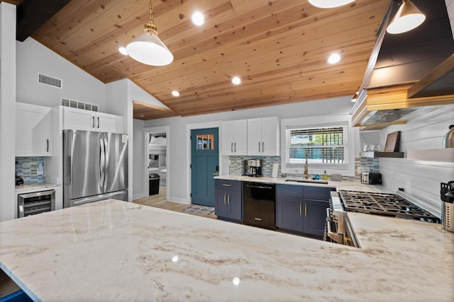 kitchen featuring hanging light fixtures, appliances with stainless steel finishes, sink, and white cabinets