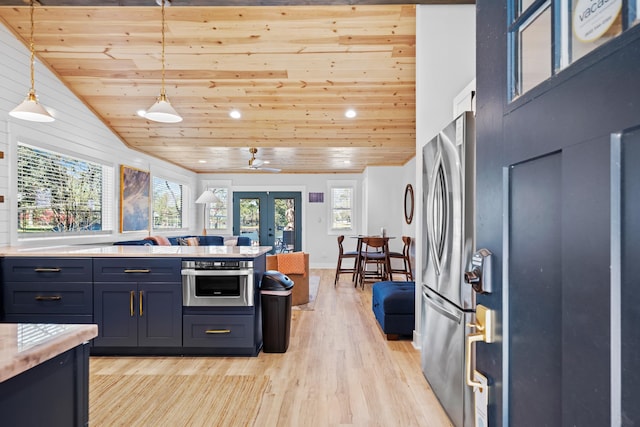 kitchen featuring lofted ceiling, hanging light fixtures, stainless steel appliances, light wood-type flooring, and french doors