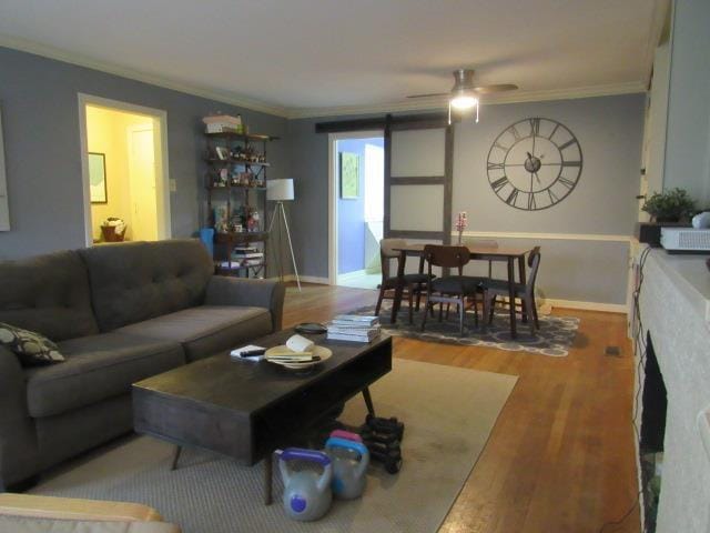 living room featuring crown molding, light hardwood / wood-style floors, and ceiling fan