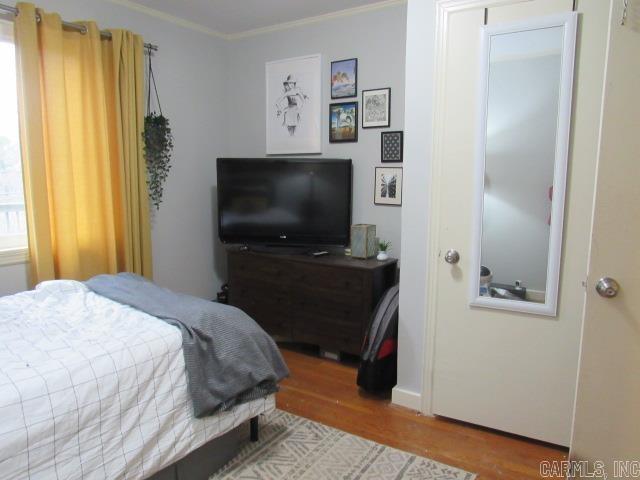 bedroom with crown molding and hardwood / wood-style flooring