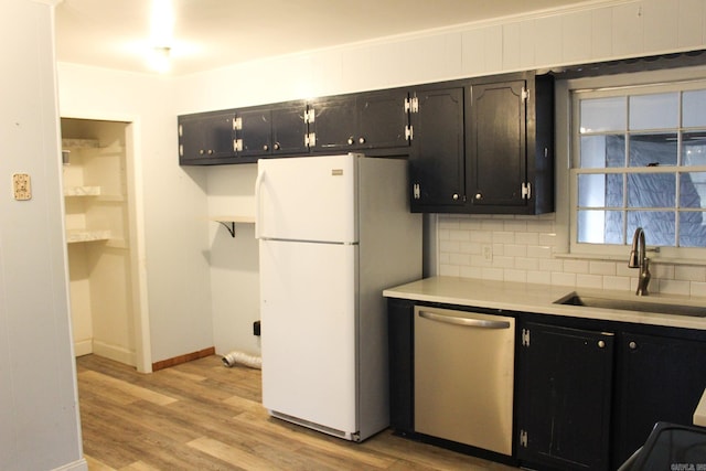 kitchen featuring sink, light hardwood / wood-style flooring, dishwasher, white fridge, and decorative backsplash