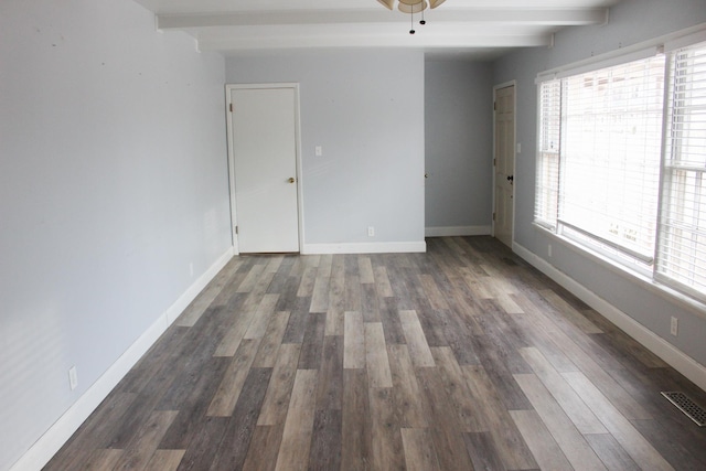 unfurnished room featuring ceiling fan, dark wood-type flooring, and beam ceiling