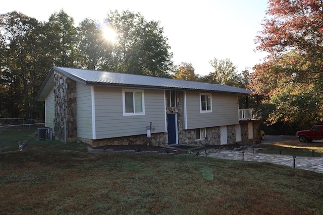 view of front facade featuring central AC and a front yard