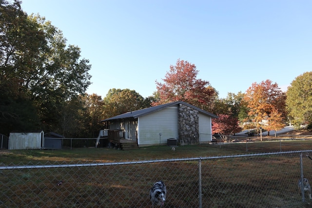 view of side of property with a yard and central air condition unit