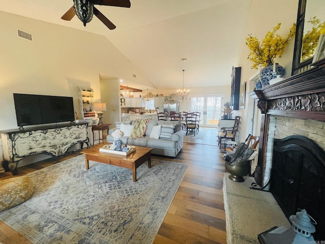living room featuring ceiling fan with notable chandelier, high vaulted ceiling, and hardwood / wood-style floors