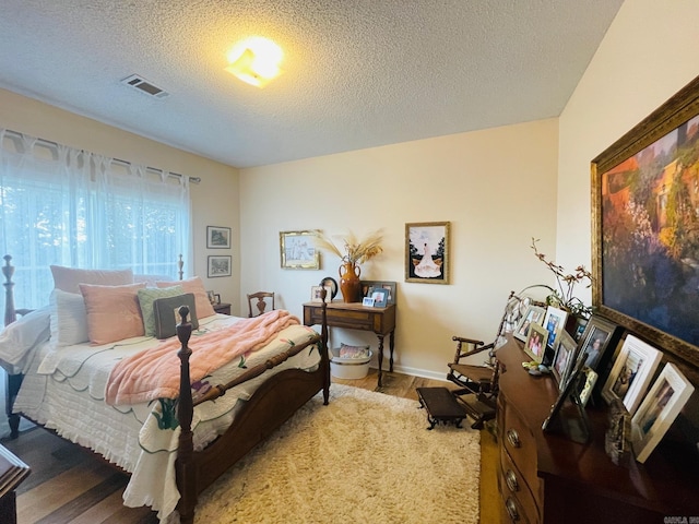 bedroom featuring hardwood / wood-style floors and a textured ceiling