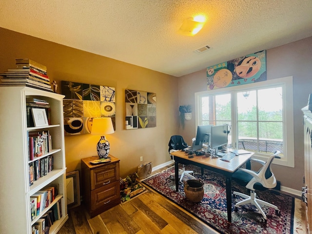 home office featuring hardwood / wood-style flooring and a textured ceiling