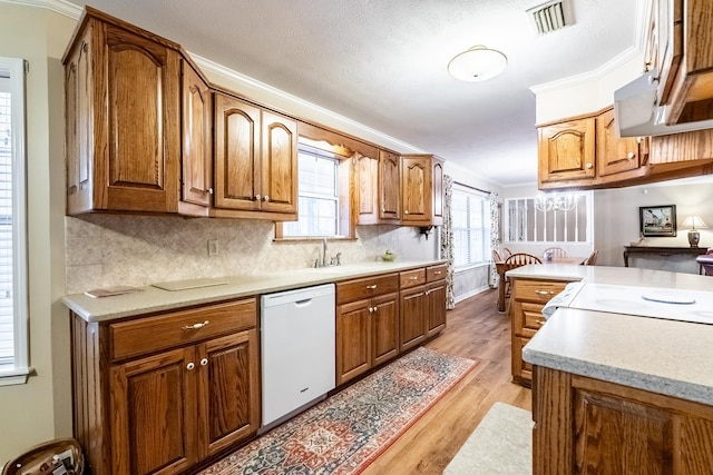 kitchen with sink, tasteful backsplash, light hardwood / wood-style flooring, ornamental molding, and dishwasher