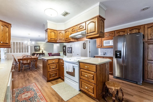 kitchen featuring a kitchen island, decorative light fixtures, ornamental molding, light hardwood / wood-style floors, and white appliances