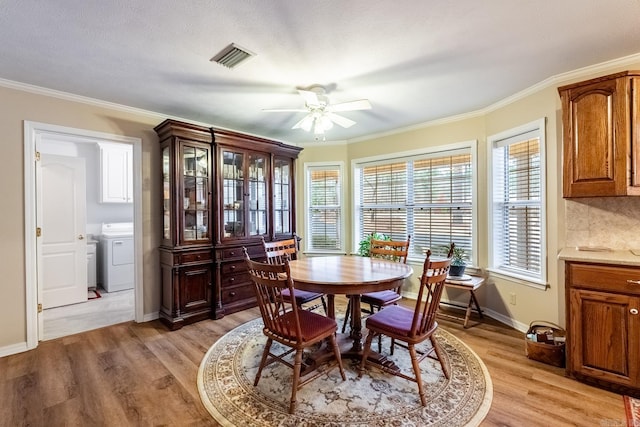 dining area with washer / clothes dryer, crown molding, ceiling fan, and light wood-type flooring