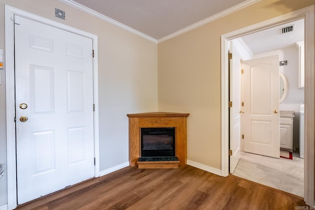 unfurnished living room featuring crown molding and wood-type flooring