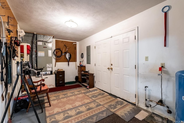 foyer entrance with hardwood / wood-style flooring, heating unit, electric panel, and a textured ceiling