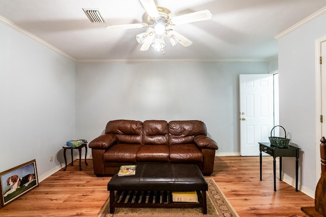 living room with hardwood / wood-style flooring, ornamental molding, and ceiling fan