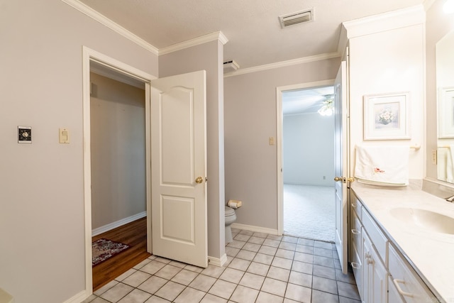 bathroom with vanity, crown molding, tile patterned floors, and toilet