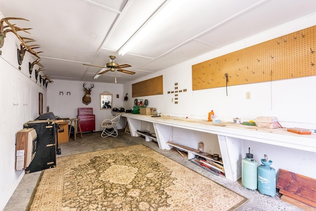 miscellaneous room with concrete flooring, ceiling fan, and a workshop area