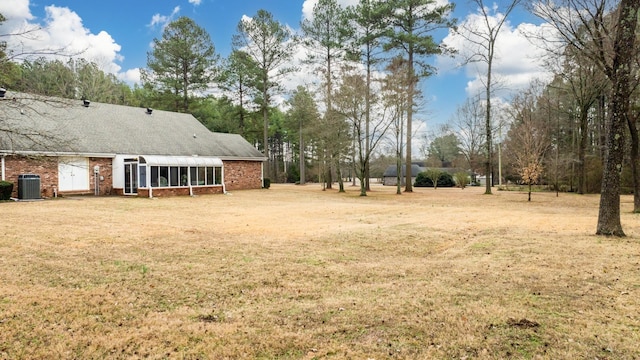 view of yard with central AC unit and a sunroom