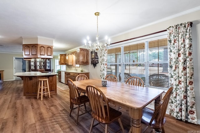 dining room featuring dark wood-type flooring, ornamental molding, and a chandelier