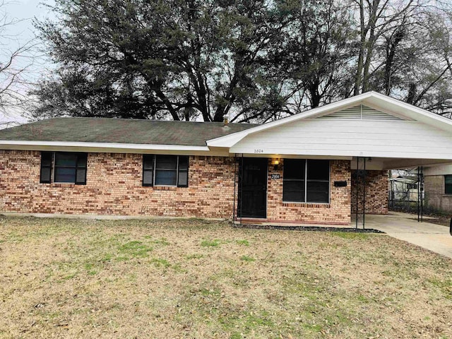 ranch-style home with a carport, driveway, brick siding, and a front lawn