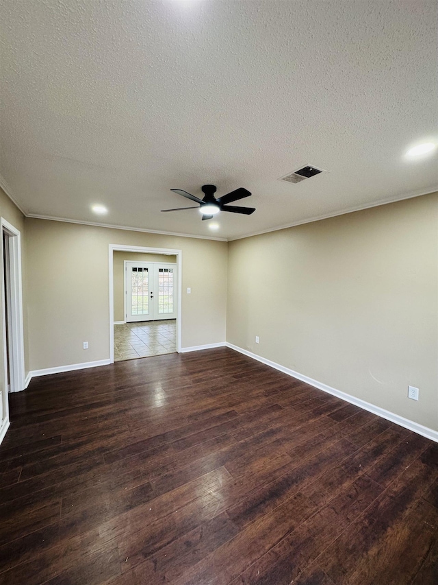 spare room with visible vents, baseboards, dark wood-style flooring, and crown molding