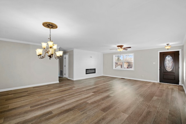 unfurnished living room featuring ceiling fan with notable chandelier, a large fireplace, ornamental molding, and hardwood / wood-style floors