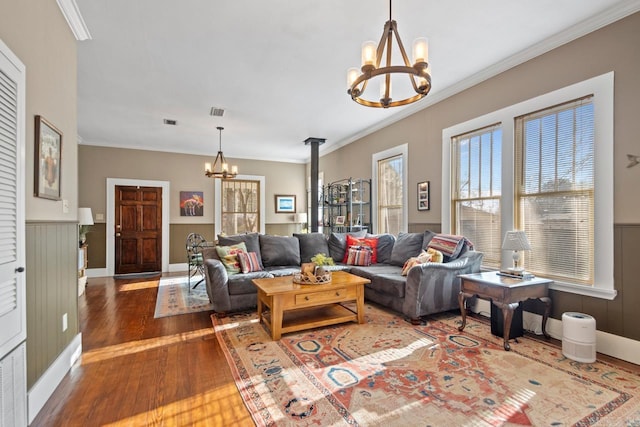 living room with crown molding, a chandelier, and hardwood / wood-style flooring