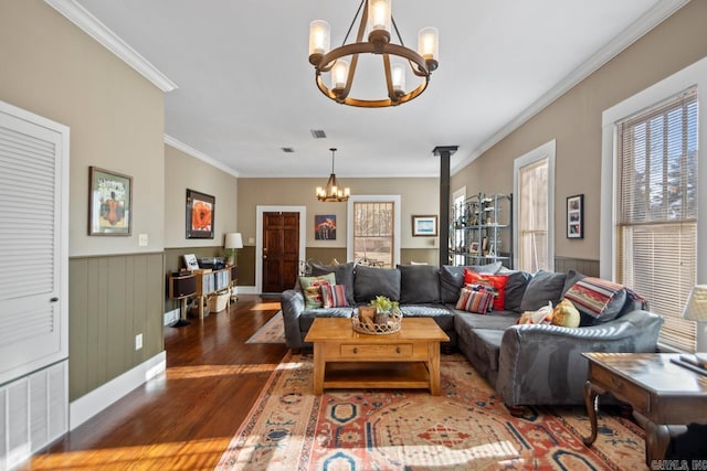 living room with a notable chandelier, dark wood-type flooring, and ornamental molding