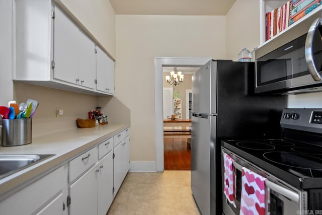 kitchen with stainless steel appliances, white cabinetry, and light tile patterned floors