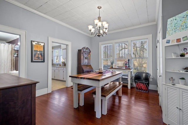 dining space featuring crown molding, dark hardwood / wood-style floors, sink, and a notable chandelier