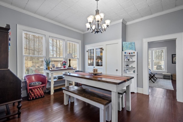 dining room with a notable chandelier, crown molding, and dark wood-type flooring