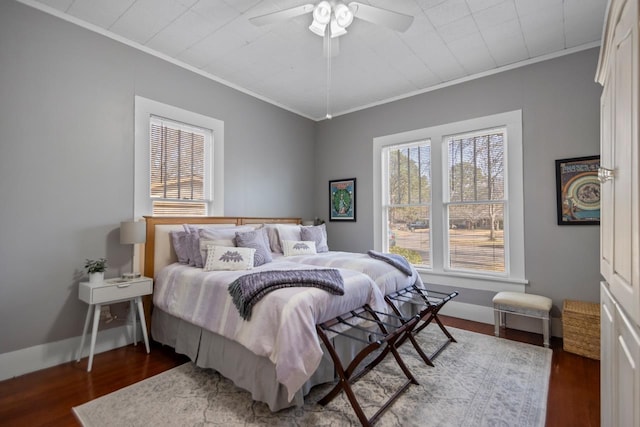 bedroom with dark wood-type flooring, ornamental molding, and ceiling fan